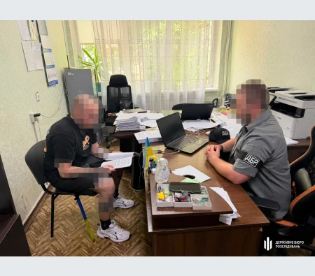 Будівля Державного бюро розслідувань України з державним прапором на фасаді.